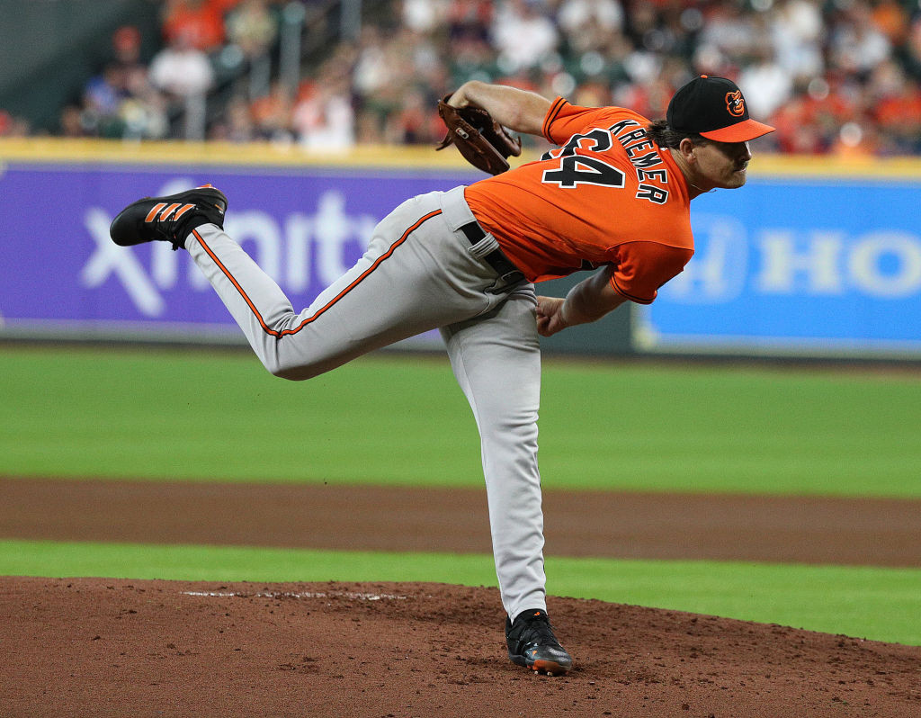 Dean Kremer pitching in orange